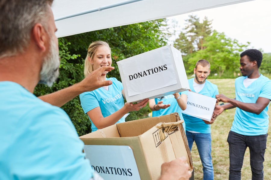 Team of people holding donation boxes outside